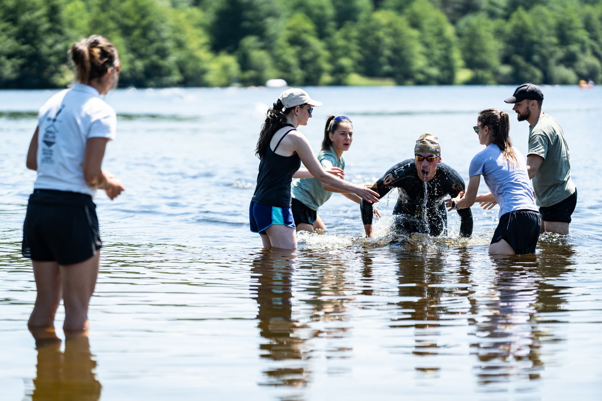 Un nageur sort du lac, accompagné par les bénévoles en 2026