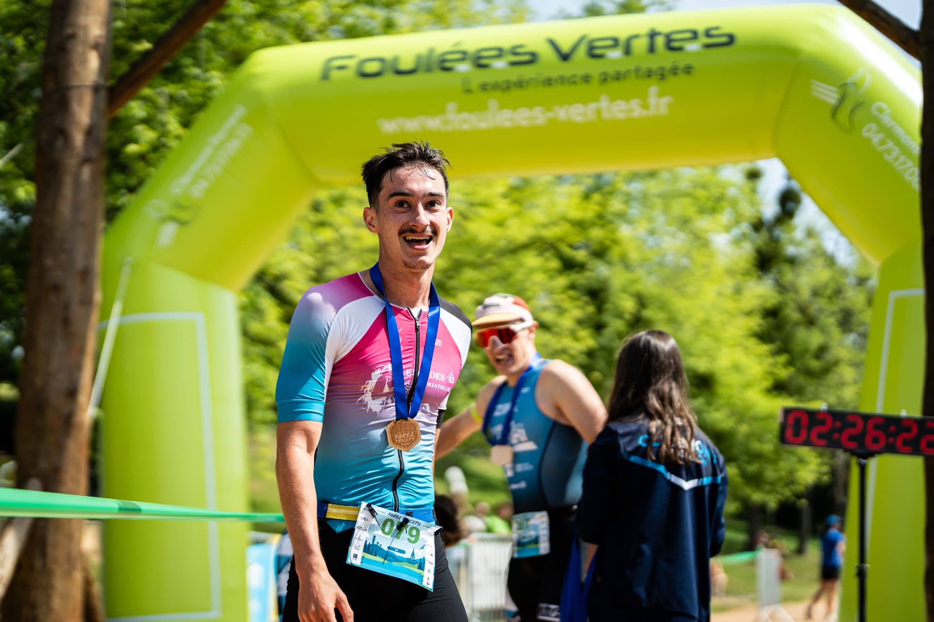 Un participant médaillé devant l’arche d’arrivée du Forez Triceps 2026